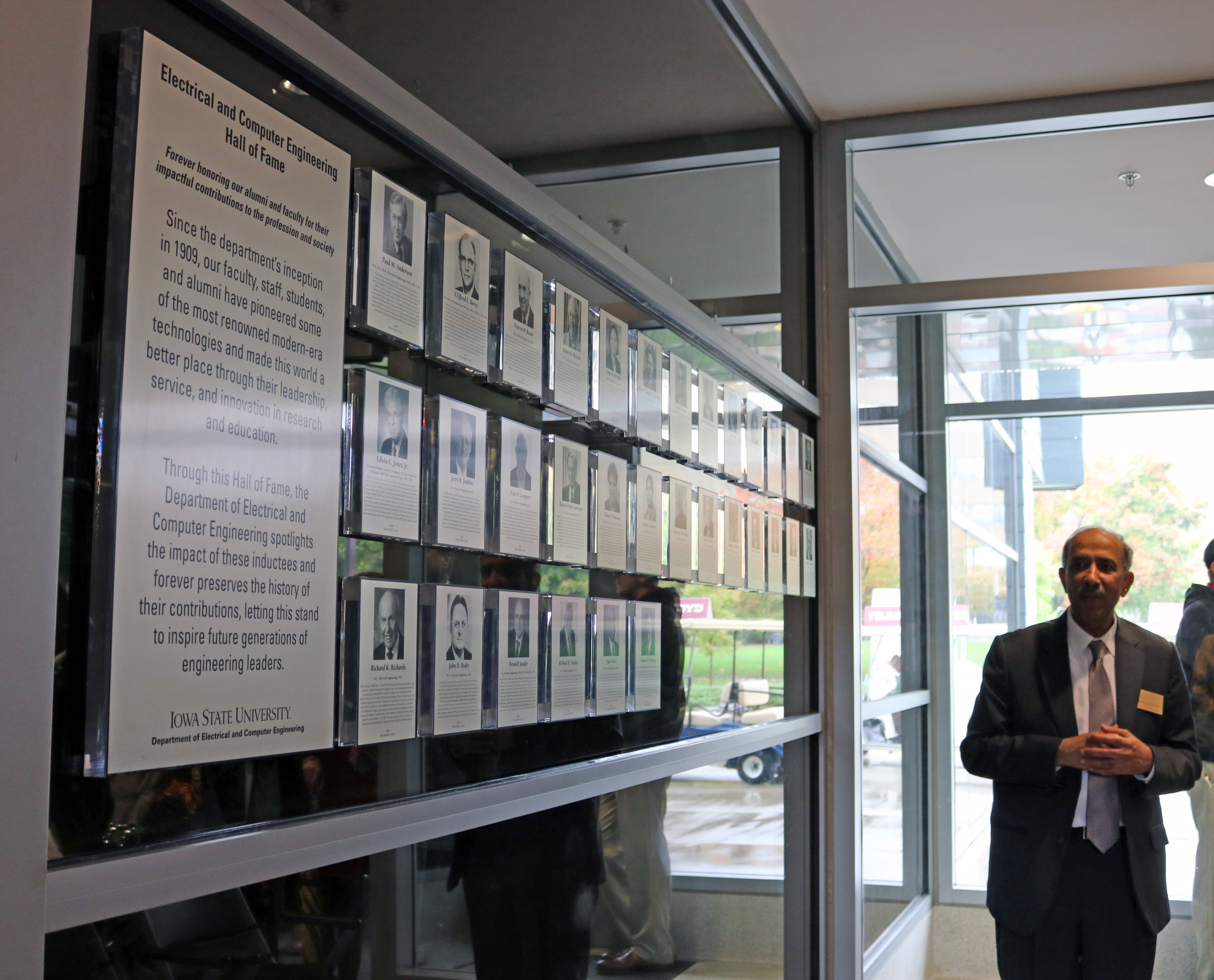 ECpE Chair Ashfaq Khokhar poses beside the new wall for the Hall of Fame